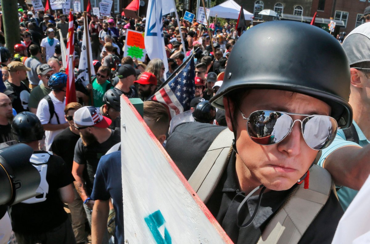 A white nationalist demonstrator with a helmet and shield walks into Lee Park in Charlottesville, Va., Saturday, Aug. 12, 2017.   