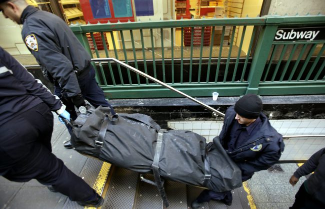 In this Jan. 22, 2013 file photo, a police officer and medical examiner personnel carry a body out of the Times Square subway station in New York after witnesses told police that the man who died jumped into the path of an oncoming train. 


