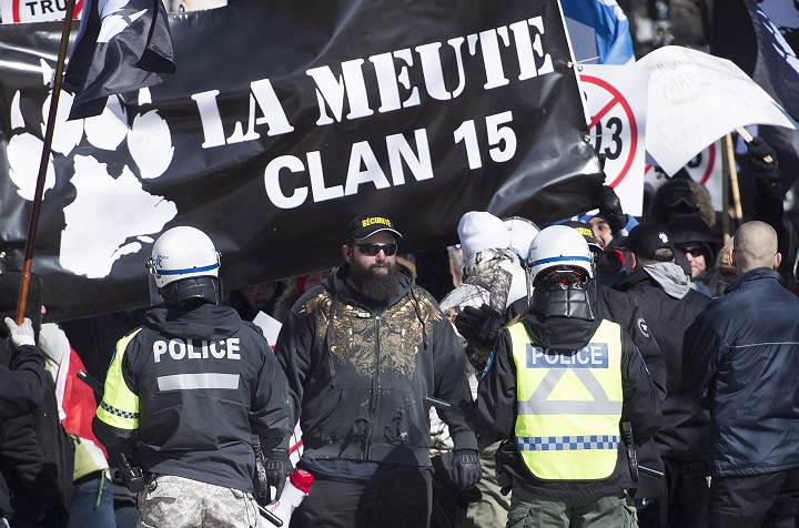 Police hold back far-right protesters during a demonstration in Montreal, Saturday, March 4, 2017. A Montreal anti-fascist group said in a statement that it's calling on anti-fascist and anti-racist groups to head to Quebec's capital to oppose a demonstration by La Meute. The right wing group has come under fire after a member was outed after participating in a white supremacist rally last week in Charlottesville, Virginia. THE CANADIAN PRESS/Graham Hughes