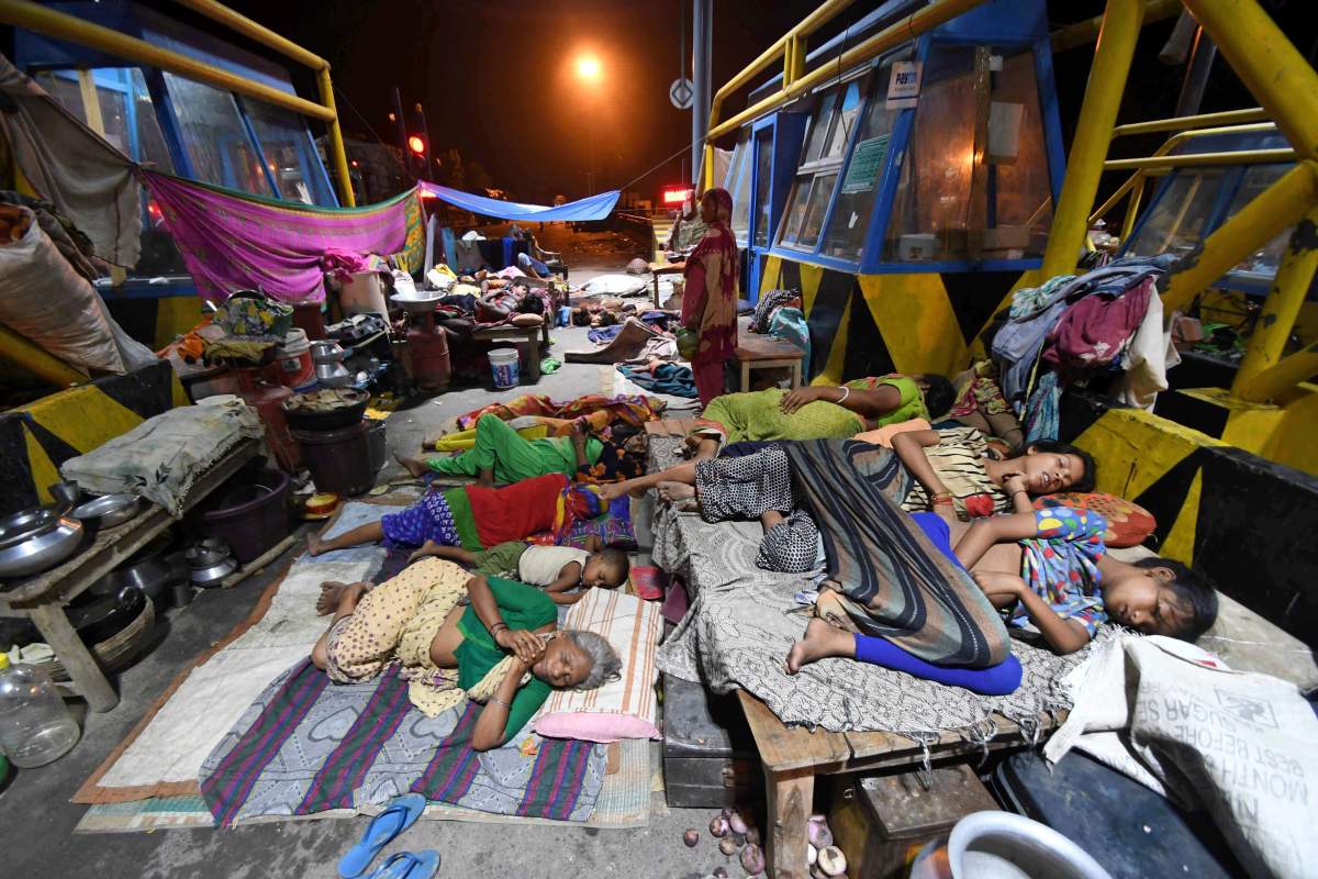 In this Aug. 19, 2017 file photo, flood-affected people sleep by the national highway toll plaza at Araria district, in the eastern Indian state of Bihar.