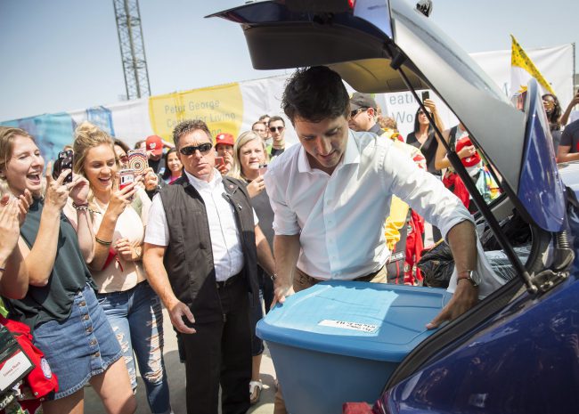 Prime Minister Justin Trudeau helps unpack the car of first-year nursing student Alex Gouveia, second from left, as she moves in to her residence at McMaster University in Hamilton, Ont., Saturday, Aug. 26, 2017. 