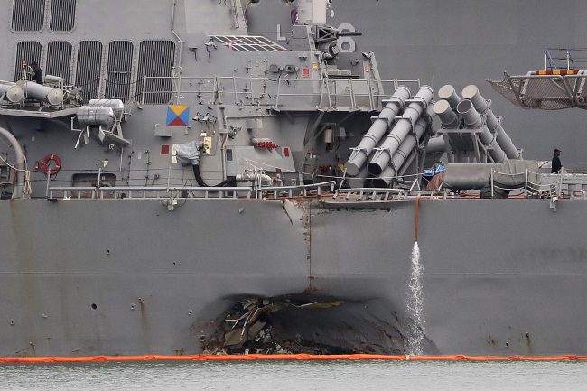 In this Aug. 22, 2017 file photo. the damaged port aft hull of the USS John S. McCain is visible while docked at Singapore's Changi naval base in Singapore.