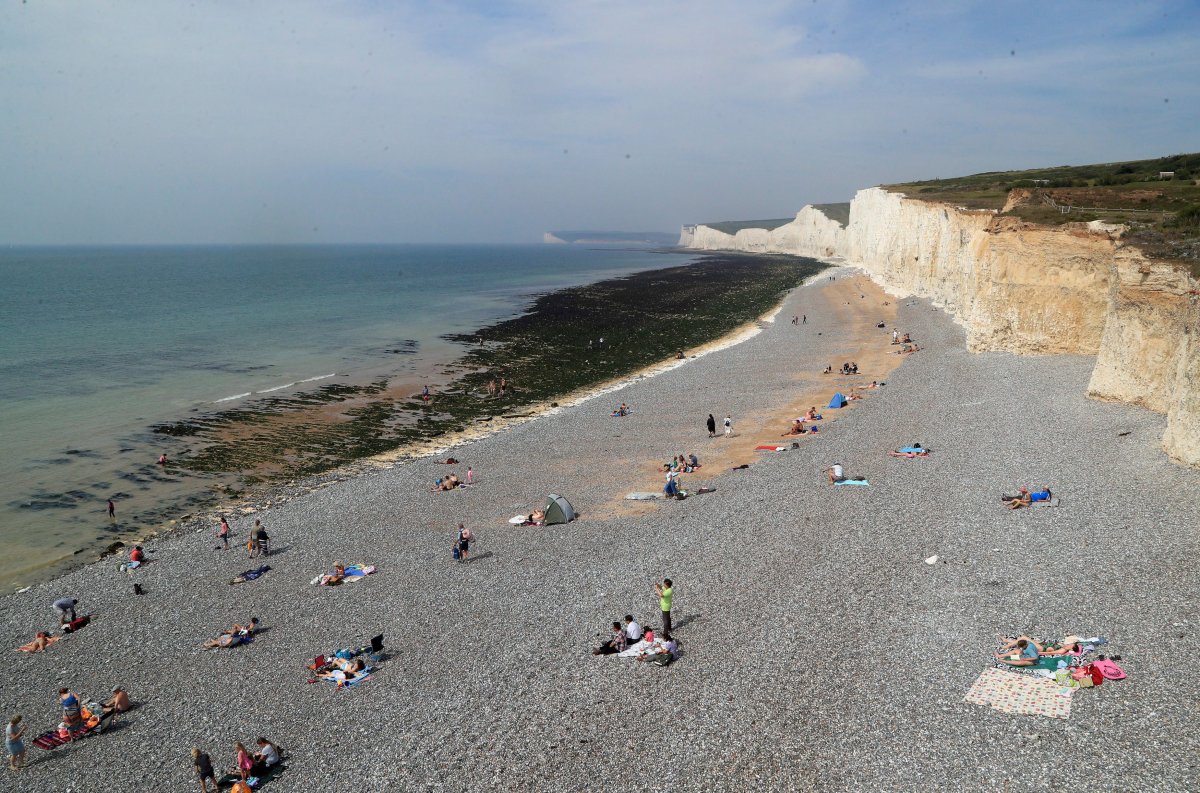 People relax on the beach at Birling Gap in Eastboune, Sussex, England, on Monday, Aug. 28, 2017. 