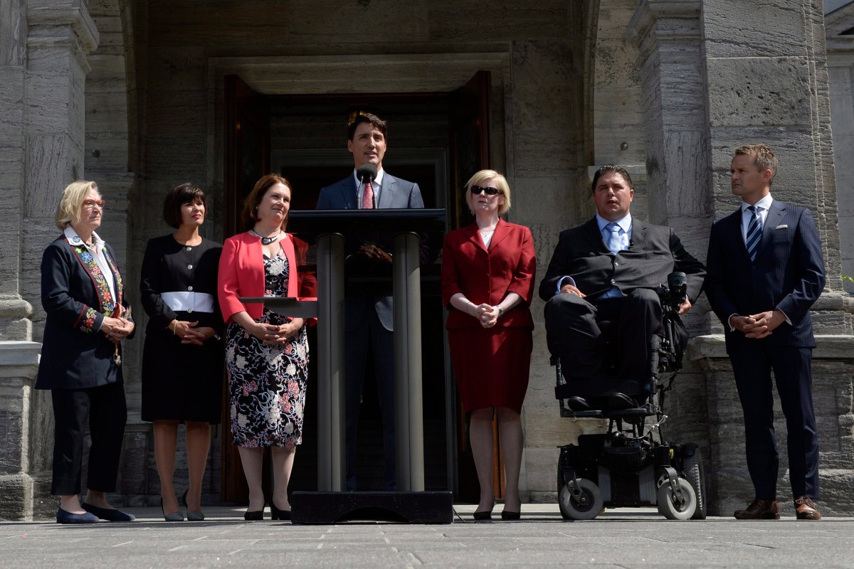 Prime Minister Justin Trudeau talks to media with members of his newly- shuffled cabinet (left to right) Carolyn Bennett, minister of Crown-Indigenous relations and northern affairs, Health Minister Ginette Petitpas Taylor, Indigenous Services Minister Jane Philpott, Public Works and Procurement Minister Carla Qualtrough, Sport and Persons with Disabilities Minister Kent Hehr and Veterans Affairs Minister Seamus O'Regan at Rideau Hall in Ottawa on Monday, Aug. 28, 2017. T.