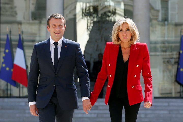 French President Emmanuel Macron and his wife Brigitte Macron walk in the Elysee Palace courtyard July 6, 2017.