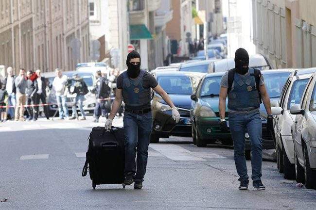 An Elite police officer pulls a suitcase after searches in Marseille, southern France, Tuesday, April 18, 2017.