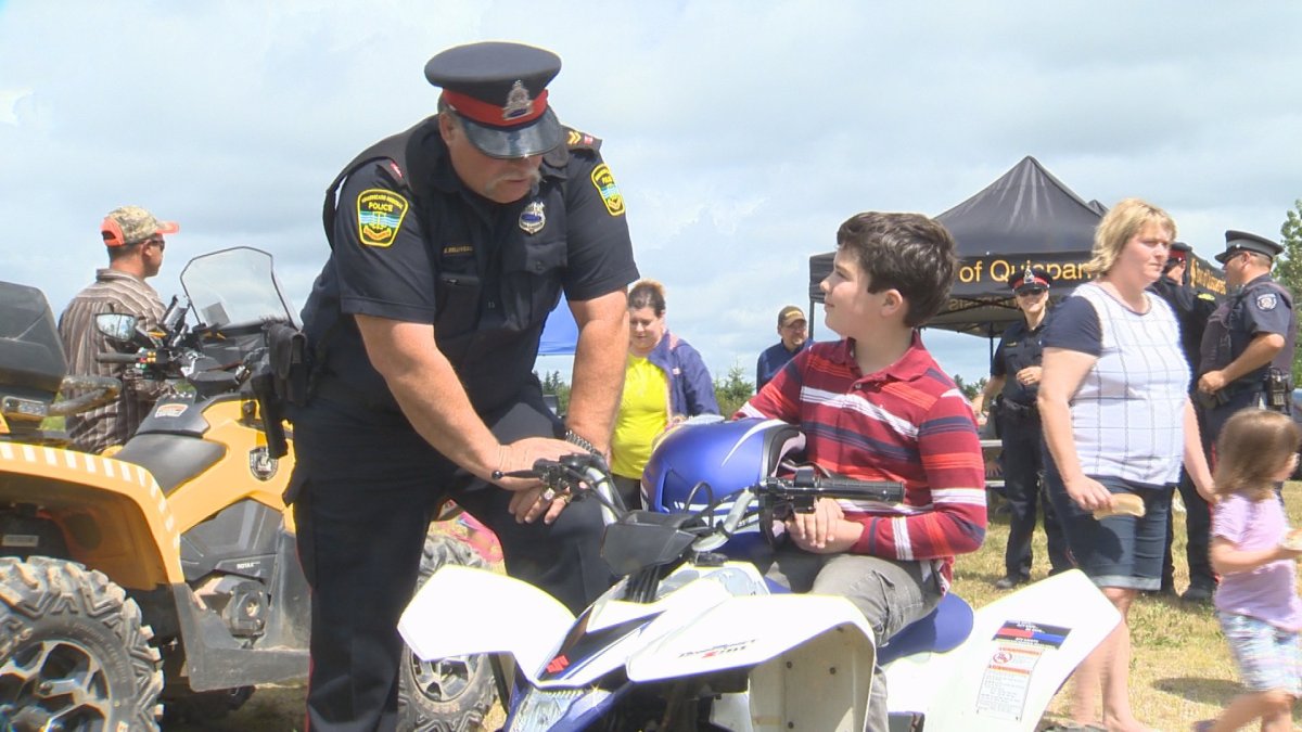 A police officer talks to a young ATV rider about safety.