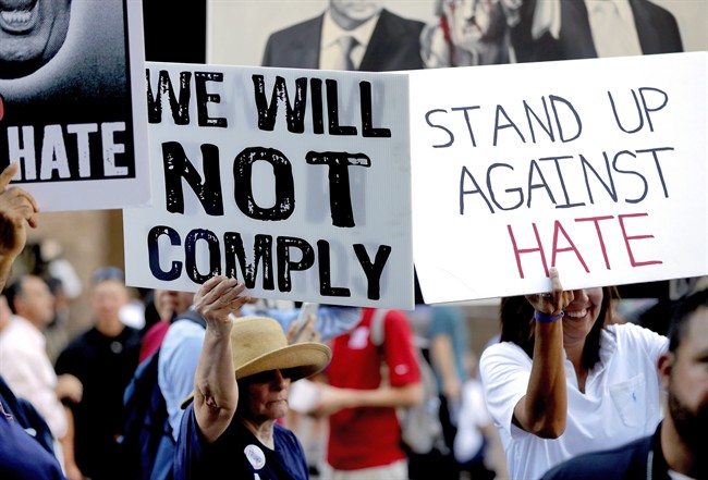 People protest outside the Phoenix Convention Center, Tuesday, Aug. 22, 2017, in Phoenix. Protests were held against President Donald Trump as planned to host a rally inside the convention center.