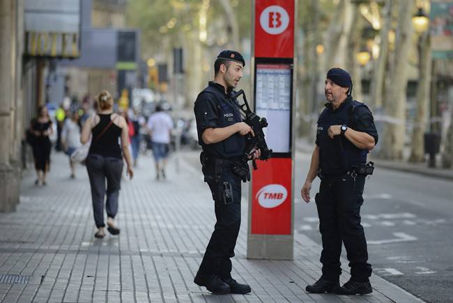 Armed police officers patrol a street in Las Ramblas, Barcelona, Spain, Friday, Aug. 18, 2017. Spanish authorities say Canada is among the countries with citizens killed or injured in the terrorist attack in Barcelona that killed at least 13, as the manhunt intensified for the perpetrators of Europe's latest rampage claimed by the Islamic State group. 
