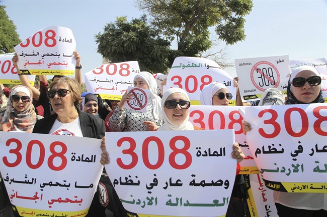 Women activists protest in front Jordan's parliament in Amman on Tuesday, August 1, 2017 with banners calling on legislators to repeal a provision that allows a rapist to escape punishment if he marries his victim.
