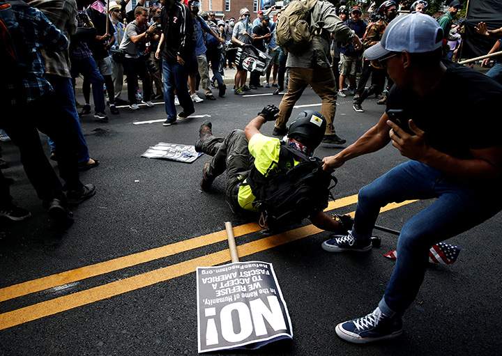 A man drags a white supremacist away from counter demonstrators after he was attacked during a rally in Charlottesville, Virginia, August 12, 2017.