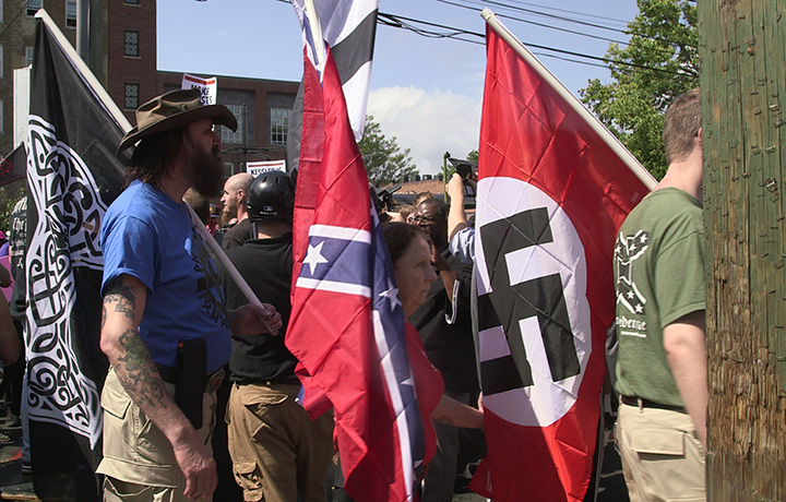 Demonstrators carry confederate and Nazi flags during the “Unite the Right” free speech rally at Emancipation Park in Charlottesville, Virginia, USA on August 12, 2017.  