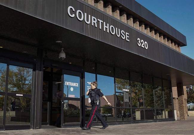 A police officer arrives at the provincial court building in Lethbridge, Alta., on Sept. 23, 2015.