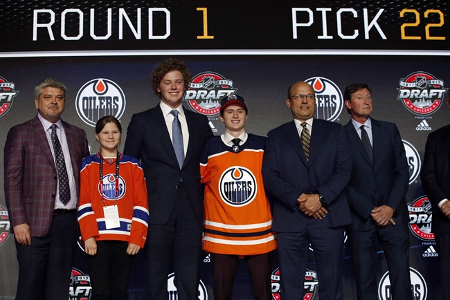 Kailer Yamamoto, center, wears an Edmonton Oilers jersey after being selected by the team during the first round of the NHL hockey draft in Chicago on June 23, 2017.