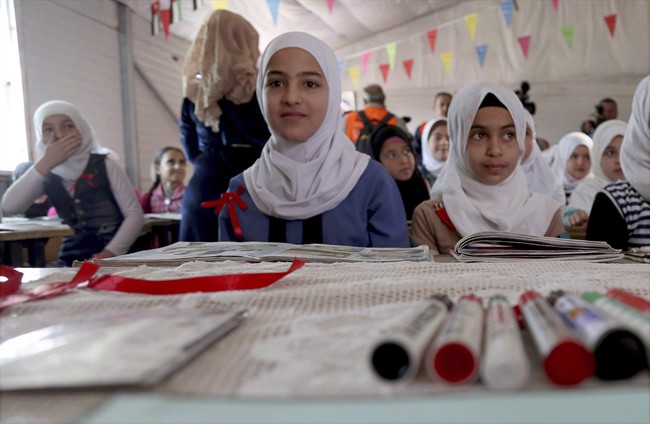 Syrian refugees pose for a photo during a visit by U.N. Secretary General Antonio Guterres to a fourth-grade classroom at the U.N.-run Zaatari camp for Syrian refugees, in northern Jordan in this March 28, 2017 file photo.