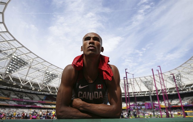 Canada's Damian Warner listens to his coach during a break in the decathlon shot put event during during the World Athletics Championships on Aug. 11, 2017.