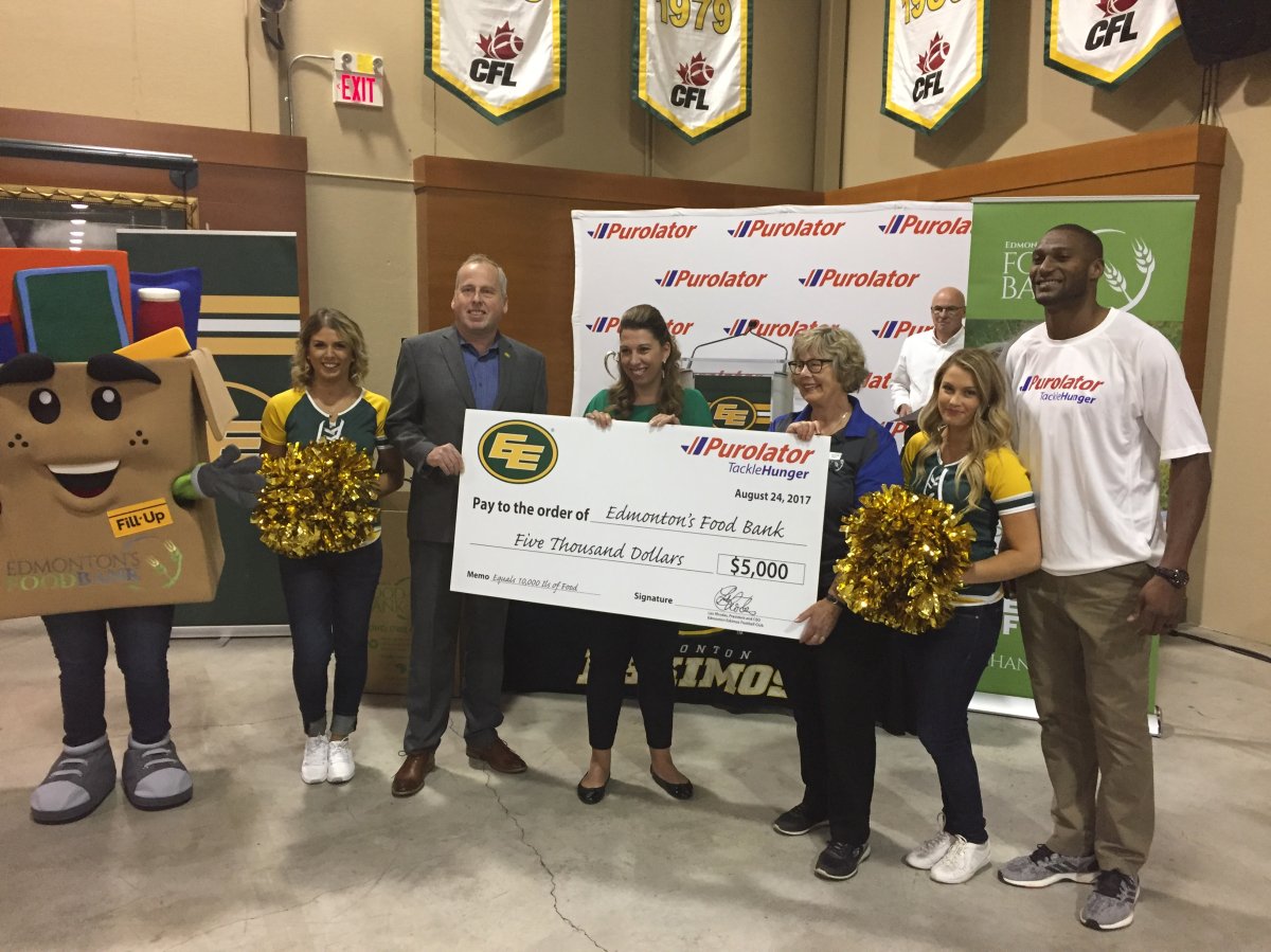 The Edmonton Eskimos present the Edmonton Food Bank with a $5,000 cheque at the Purolator Tackle Hunger media launch Aug. 24, 2017.