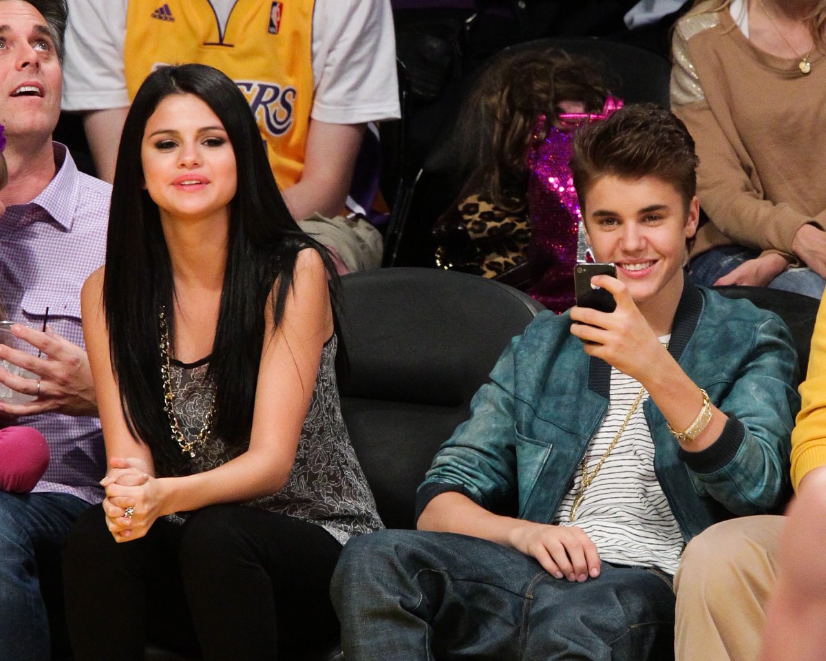 Selena Gomez (L) and Justin Bieber attend a basketball game between the San Antonio Spurs and the Los Angeles Lakers at Staples Center on April 17, 2012 in Los Angeles, California.