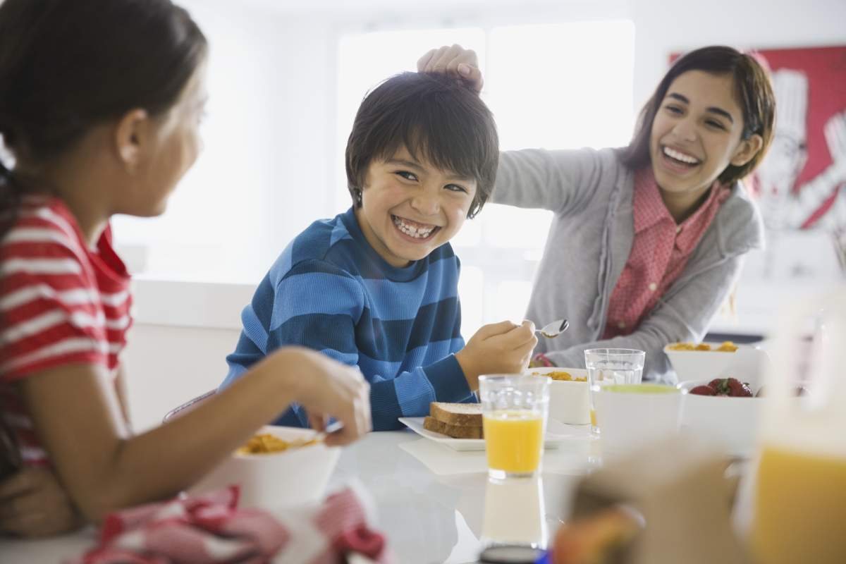 Playful siblings having breakfast together.