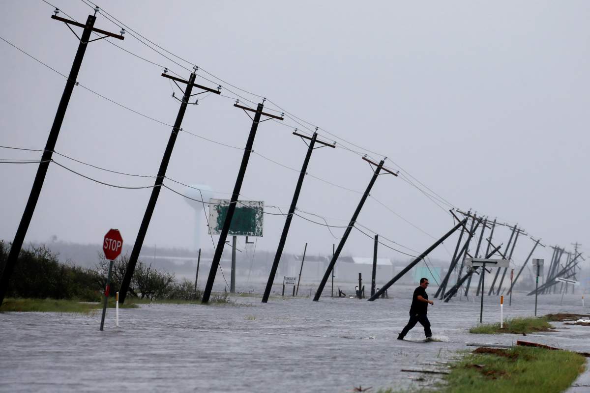 A man walks through floods waters and onto the main road after surveying his property which was hit by Hurricane Harvey in Rockport, Texas, U.S. August 26, 2017.