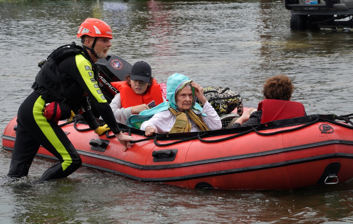 A family is rescued from flood waters from Hurricane Harvey on a boat in Dickinson, Texas August 27, 2017. 