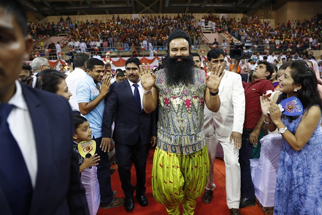 In this Oct. 5, 2016 file photo, Indian spiritual guru who calls himself Saint Dr. Gurmeet Ram Rahim Singh Ji Insan, center, greets followers as he arrives for a press conference ahead of the release of his new movie "MSG, The Warrior Lion Heart," in New Delhi, India.