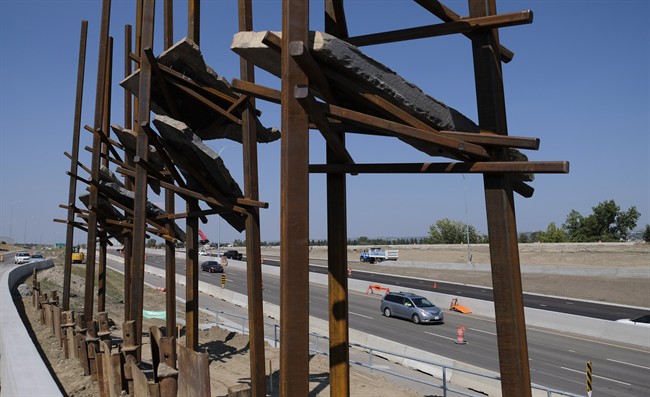 Traffic passes a sculpture by New York artist Del Geist, which is called "Bowfort Towers" and is located near Canada Olympic Park in Calgary, Alta., Wednesday, Aug. 9.