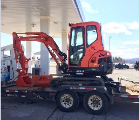 This is a photo of the stolen trailer and excavator that police are looking for.