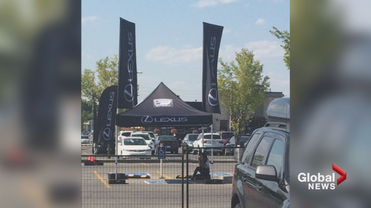 A Lexus Canada tent and flags are seen covering accessible parking spots at Calgary's Southcentre Mall. 