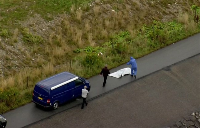 Police forensic investigators prepare to move a headless body of a woman that was found near Amager Denmark in the Baltic Sea where Wall went missing.