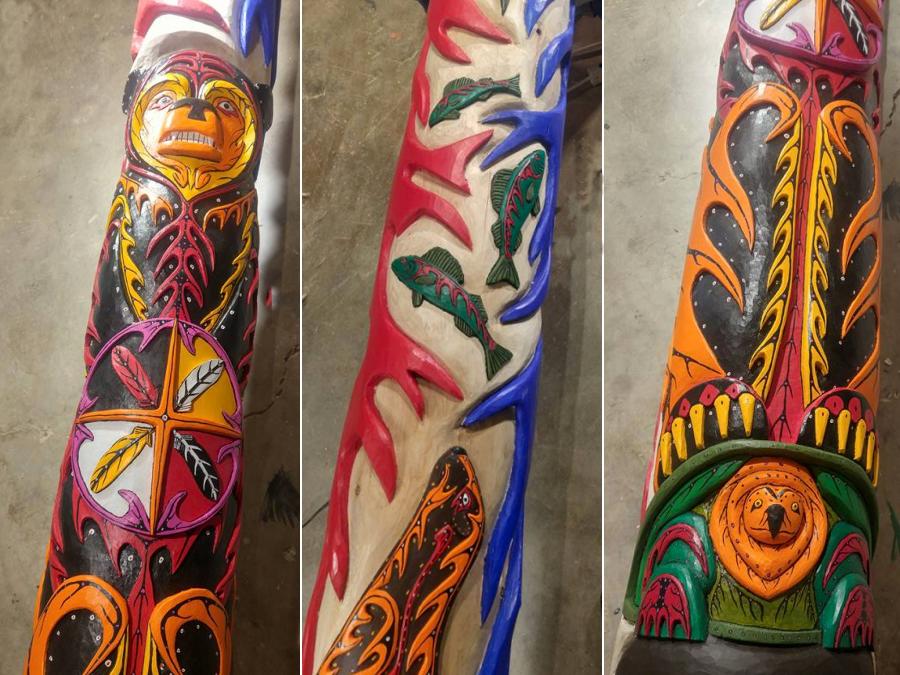 The totem pole features a variety of symbols and animals representing strength and unity.