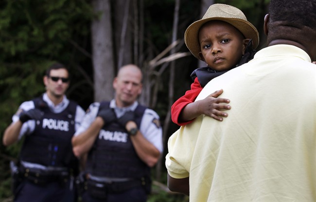 A Haitian boy holds onto his father as they approach an illegal crossing point in August 2017.