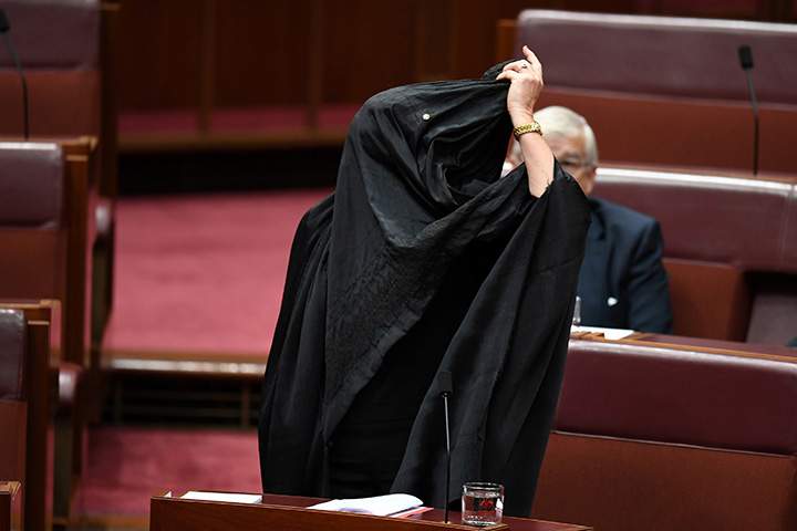 Australian One Nation party leader, Senator Pauline Hanson pulls off a burka in the Senate chamber at Parliament House in Canberra, Australia, August 17, 2017.