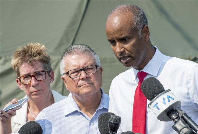 Ahmed Hussen, right, Minister of Immigration, Refugees and Citizenship, Ralph Goodale, Minister of Public Safety and Emergency Preparedness, and Brenda Shanahan, MP for Chateauguay-Lacolle, comment on the influx of asylum seekers crossing the border into Canada from the United States Monday, August 21, 2017 near Saint-Bernard-de-Lacolle, Que. THE CANADIAN PRESS/Paul Chiasson.