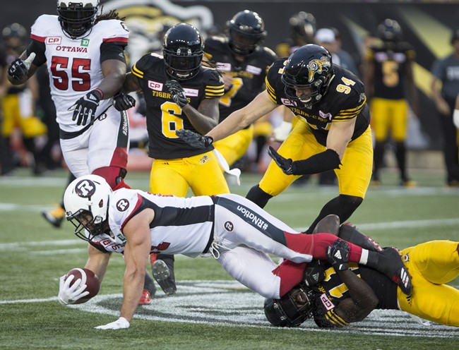 Ottawa Redblacks fullback Patrick Lavoie (81) is tackled by Hamilton Tiger-Cats linebacker Larry Dean (11) during CFL Football action in Hamilton, Ont. on Friday, August 18, 2017.