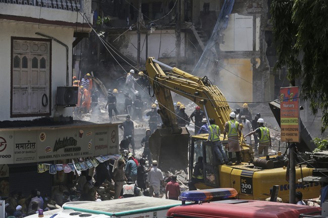 Rescue workers clear debris from the site of a building collapse in Mumbai, India, Thursday, Aug. 31, 2017. A five-story building collapsed Thursday in Mumbai, Indian‚Äôs financial capital, after torrential rains lashed western India. (AP Photo/Rafiq Maqbool).
