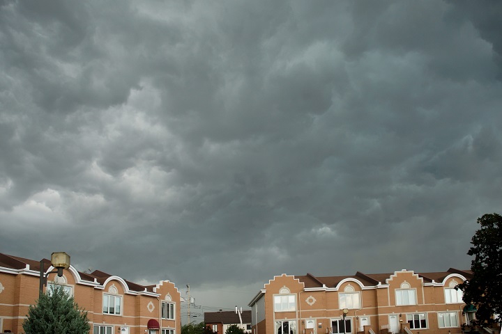 In this file photo, ominous storm clouds gather over Montreal as a severe storm front hits regions of Quebec. A storm system over Montreal Friday led to flooding in the south shore community of Napierville, prompting the municipality to declare a state of emergency. Saturday, Aug. 5, 2017.