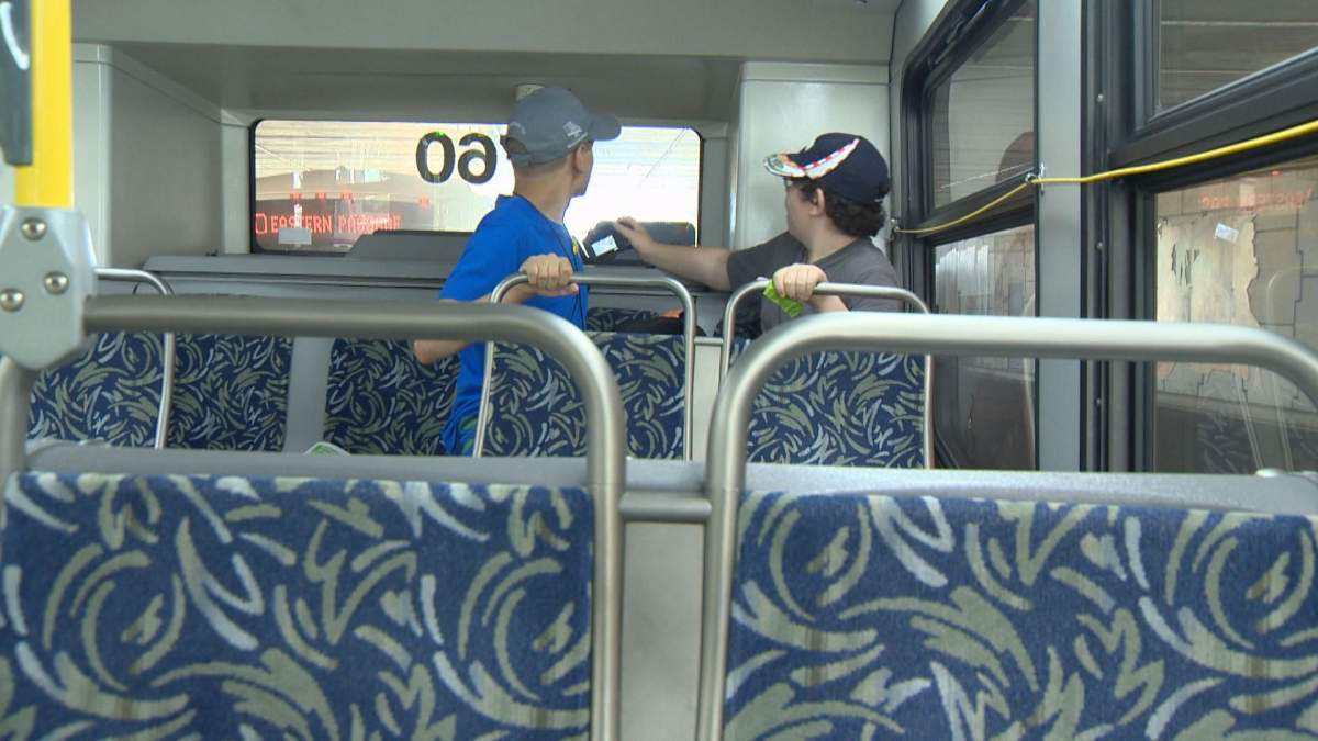 Finn MacDonald (left) and Luke Coward-Yaskiw wait on a Halifax Transit bus at the Dartmouth Bridge Terminal on Aug. 22, 2017.