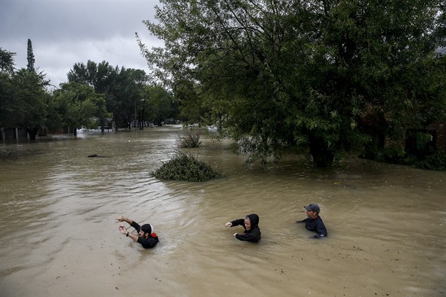 People wade through chest deep water down Pine Cliff Drive as Addicks Reservoir nears capacity due to near constant rain from Tropical Storm Harvey Tuesday, Aug. 29, 2017 in Houston.