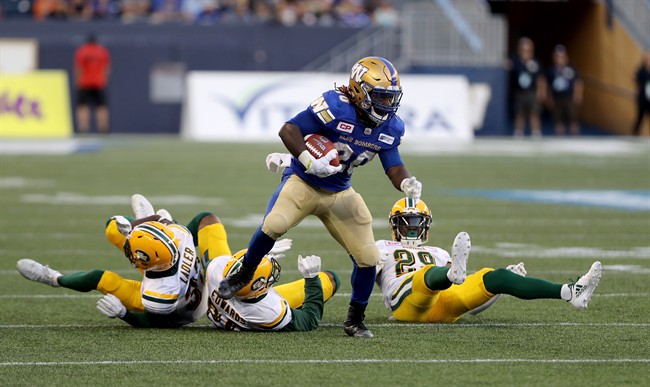 Edmonton Eskimos' Kenny Ladler, Mercy Maston and Chris Edwards can't bring down Winnipeg Blue Bombers' Timothy Flanders during a CFL game in Winnipeg on Aug. 17, 2017.
