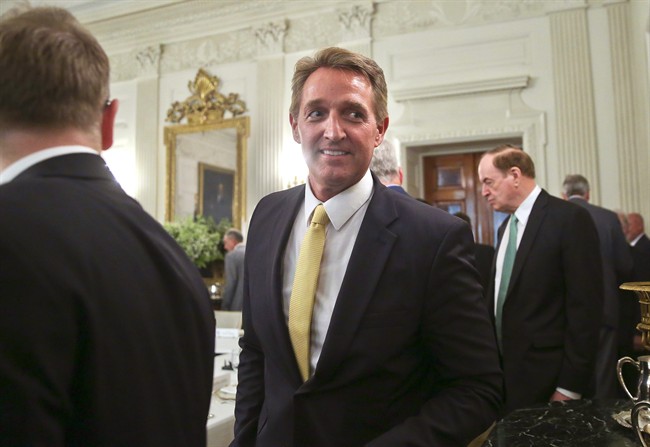 FILE - In this July 19, 2017, file photo, Sen. Jeff Flake, R-Ariz., centre, walks to his seat as he attends a luncheon with other GOP Senators and President Donald Trump in the State Dinning Room of the White House.