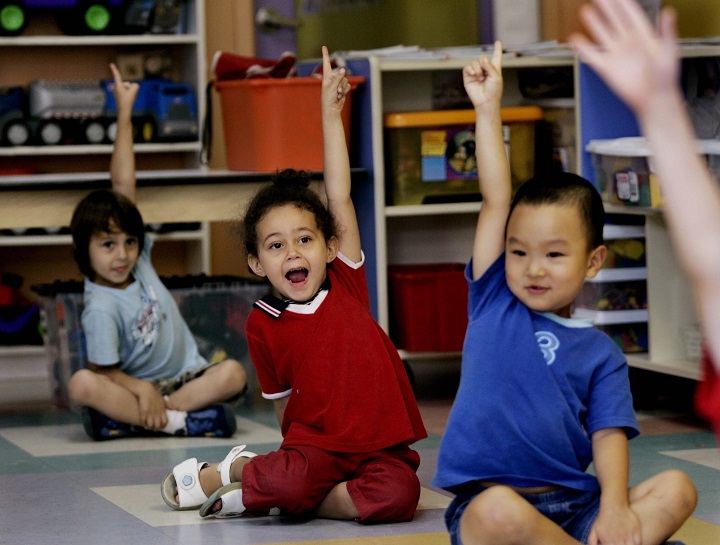In this file photo, Children put up their hands for ice cream at a daycare centre in Montreal. Workers in subsidized daycare centres across the province voted in favour of a six-day strike mandate. Thursday, Sept. 28, 2017.