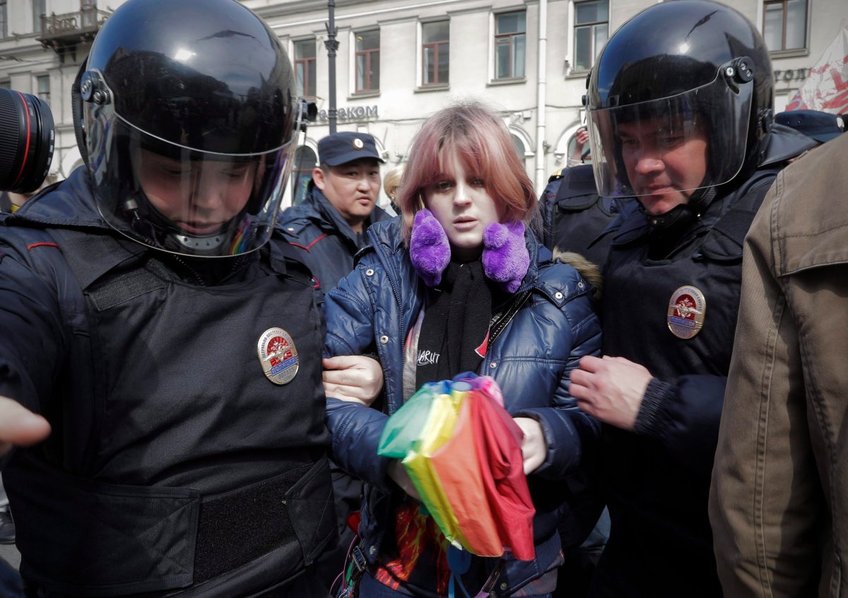 In this Monday, May 1, 2017 file photo, a gay rights activist holding a rainbow umbrella is detained by police during a rally marking May Day in downtown St. Petersburg, Russia. In the past two months, there have been large-scale detentions of gay men in Nigeria and Bangladesh, and chilling accounts of roundups and torture of scores of gays in Chechnya. 