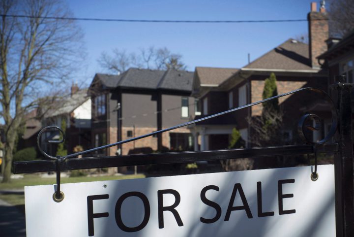 A "For Sale" sign is shown in front of west-end Toronto homes Sunday, April 9, 2017. 