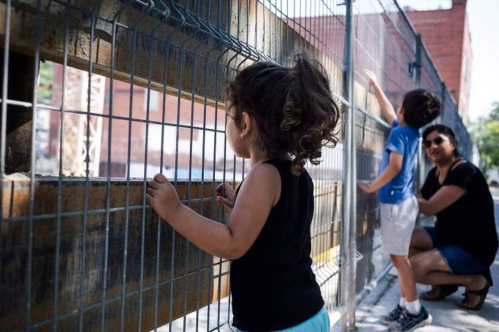 Serina Manek watches condo construction underway in the Leslieville neighbourhood in Toronto, with her two children Mia Partridge (3), left, and Zane Partridge (5), centre.