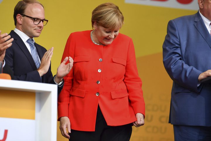 In this Sept. 5, 2017 photo German Chancellor Angela Merkel looks at a stain on her jacket during a campaign event at the University Square in Heidelberg, Germany.