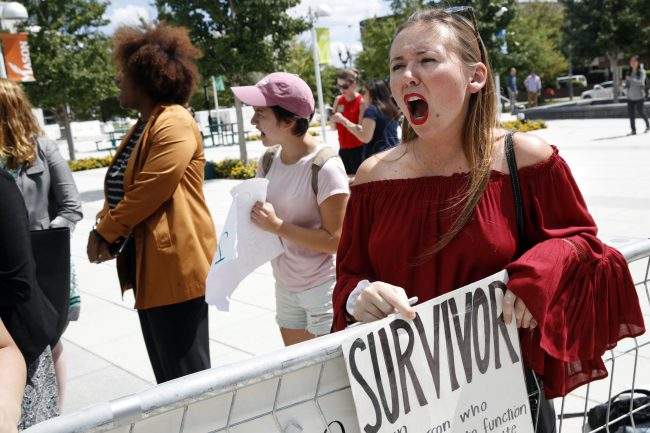 Meghan Downey, 22, a recent graduate from the College of William & Mary, reacts outside an auditorium after Education Secretary Betsy DeVos spoke about proposed changes to Title IX, Sept. 7, 2017, at George Mason University Arlington, Va.


