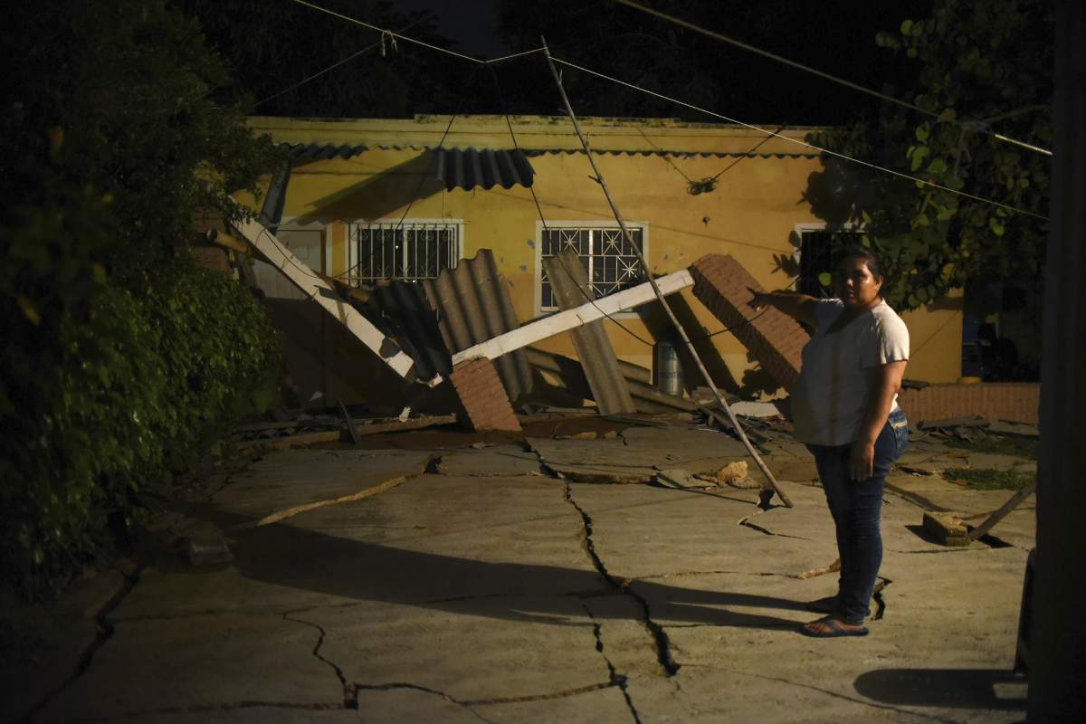 A woman points at her damaged house in Coatzacoalcos, in the Veracruz state of Mexico, after a 8.2 magnitude earthquake violently shook Mexico, early 08 September 2017.