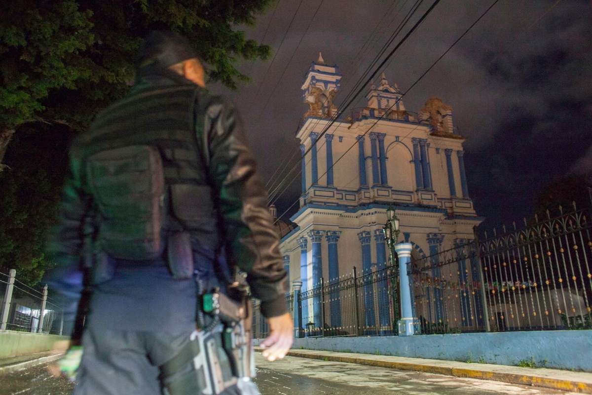 A policeman stands in front of a church whose towers were damaged by an 8.1-magnitude earthquake in San Cristobal de Las Casas, state of Chiapas, Mexico, early Friday, Sept. 8, 2017.