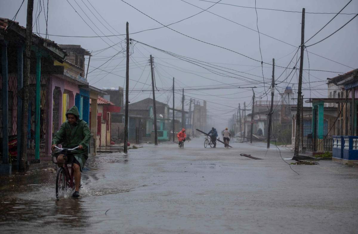 Residents ride their bikes through flood waters in the aftermath of Hurricane Irma, in Caibarien, Cuba, Saturday, Sept. 9, 2017.